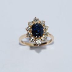 a blue and white diamond ring sitting on top of a table