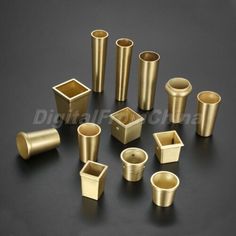 various sizes and shapes of brass cups on a black surface with one cup in the middle