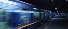 the train is moving fast through the subway station in the dark, it's blurry