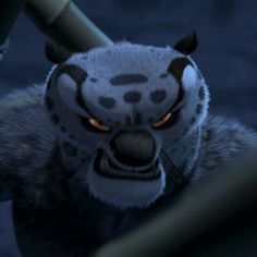 an angry looking animal with yellow eyes and fur on it's head, standing next to a metal pole