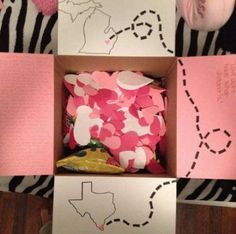 a box filled with pink and white confetti on top of a zebra print blanket