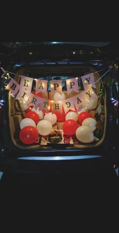 an open trunk filled with balloons and streamers