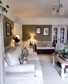 a living room filled with white furniture and decor