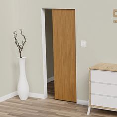 an empty room with a white vase and wooden door