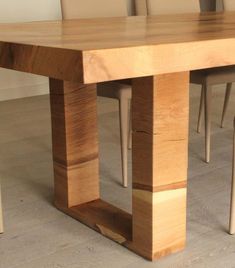 a wooden table with chairs around it in the middle of an empty floored room