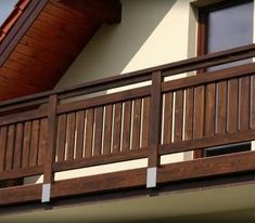 a wooden balcony next to a white house