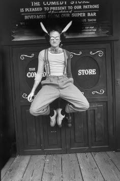 an old black and white photo of a woman jumping in the air with her hands up