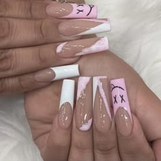 two hands with pink and white nail designs on them