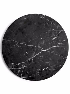 a round black marble table top with white veining on the edges and an oval shape