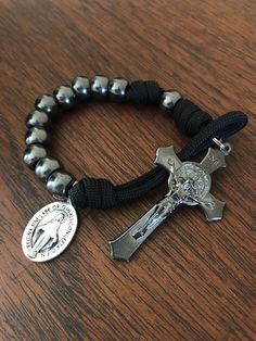 "Hand-tied Pocket Rosary with Black Paracord, approximately 9\" long. Beads are solid metal with a Gunmetal finish.... St. Benedict crucifix in gunmetal finish, 2\" long and beautifully detailed.  Pocket rosary comes with 1 saint medal of your choice. (Miraculous medal shown) End loop is large enough for crucifix to pass through easily.  **Carabiner clips available for $2. Locking style closure for security, comes in BLACK or SILVER finish Pocket Rosaries make everyday prayer more convenient Sma Holy Spirit Come, Decade Rosary, Prayer Bracelet, Tactical Bag