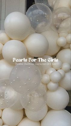 white balloons are stacked on top of each other in front of a building with the words pearls for the girls