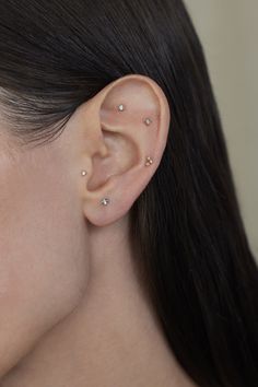 a close up of a person wearing a pair of ear piercings on their ears