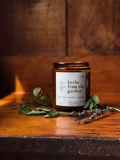 a jar of herbs sits on a wooden table