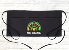 a black apron with the words mrs gonzaez on it and an image of a rainbow