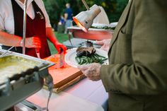 two people preparing food at an outdoor event