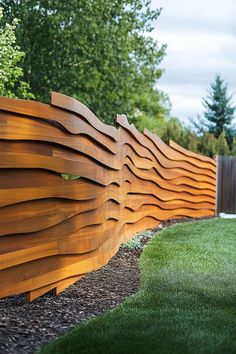 a wooden fence in the middle of some grass