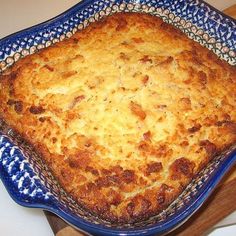 a casserole dish is sitting on a wooden cutting board, ready to be eaten