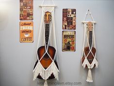 there are two guitars hanging on the wall with macrame strings attached to them