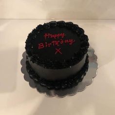 a black birthday cake with red writing on it