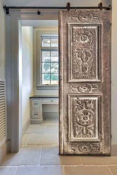 an old door is opened to reveal a room with white walls and tile flooring