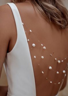 the back of a woman's dress with pearls on it