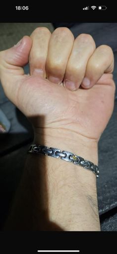 a man's hand with a bracelet on it