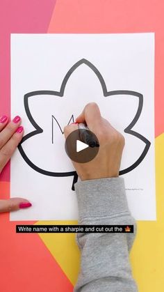 someone is drawing a flower on a piece of paper