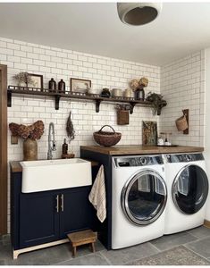 a washer and dryer in a small room with shelves above the washer