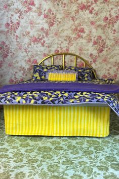 a doll house bed with purple and yellow bedspread on the bottom, next to floral wallpaper