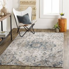 a white chair sitting on top of a wooden floor next to a rug covered in flowers