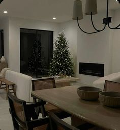 a dining room table and chairs with a christmas tree in the background