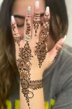 a woman's hand with henna tattoos on it