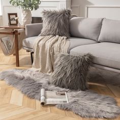 a living room filled with furniture and pillows on top of a hard wood floored floor