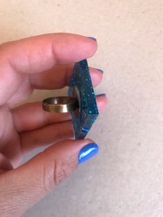 This is an adjustable ring made with epoxi resine and blue sparkling mica. Each piece is unique, handmade fabrication. The resin itself is sealer and water proof but to increase the longevity of the ring band itself the ring should be removed before hand washing and should avoid contact with house hold cleaners. We strive for 100% customer satisfaction. If any problems are encountered upon receipt, please notify me for a quick and friendly resolution. Don't forget to make sure your Etsy address Unique Blue Resin Rings, Handmade Blue Resin Rings, Blue Resin Rings For Gifts, Blue Resin Rings Perfect As Gifts, Blue Resin Rings Perfect For Gifts, Handmade Rectangular Blue Ring, Handmade Blue Rectangular Rings, Blue Geometric Jewelry As A Gift, Blue Geometric Jewelry For Gifts