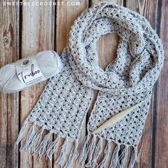 a crocheted scarf and knitting kit on a wooden surface