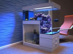 a fish tank with purple flowers in it next to a pink chair and wallpaper