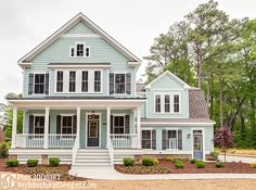 a blue house with white trim on the front porch and two story, three car garage