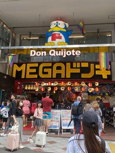 people are walking around in front of a building with a sign that says don quijote megaplay 4