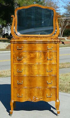 an old wooden dresser with a mirror on it's top and bottom drawer open