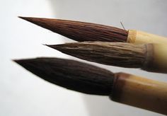 two wooden brushes with brown bristles on top of each other in close up view