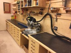 a workbench with many drawers and tools on the wall, including a grinder