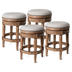 four wooden stools with white upholstered cushions