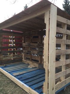 a wooden structure with blue slats on the bottom and sides that are made out of pallets