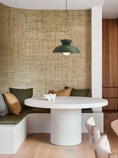 a white table and bench in a room with wood paneling on the wall behind it