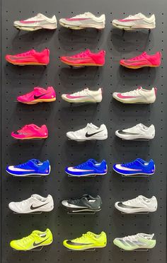 there are many different colors of shoes on the wall in this display case at the nike store