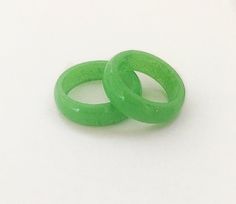 two green rings sitting next to each other on a white surface