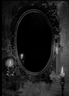 a mirror and two candles on a table