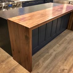 a kitchen island made out of wood in the middle of a hardwood flooring area