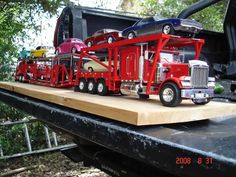 toy cars are stacked on the back of a truck