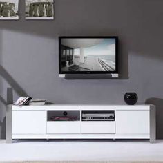 a living room with grey walls and white furniture in the center is a flat screen tv